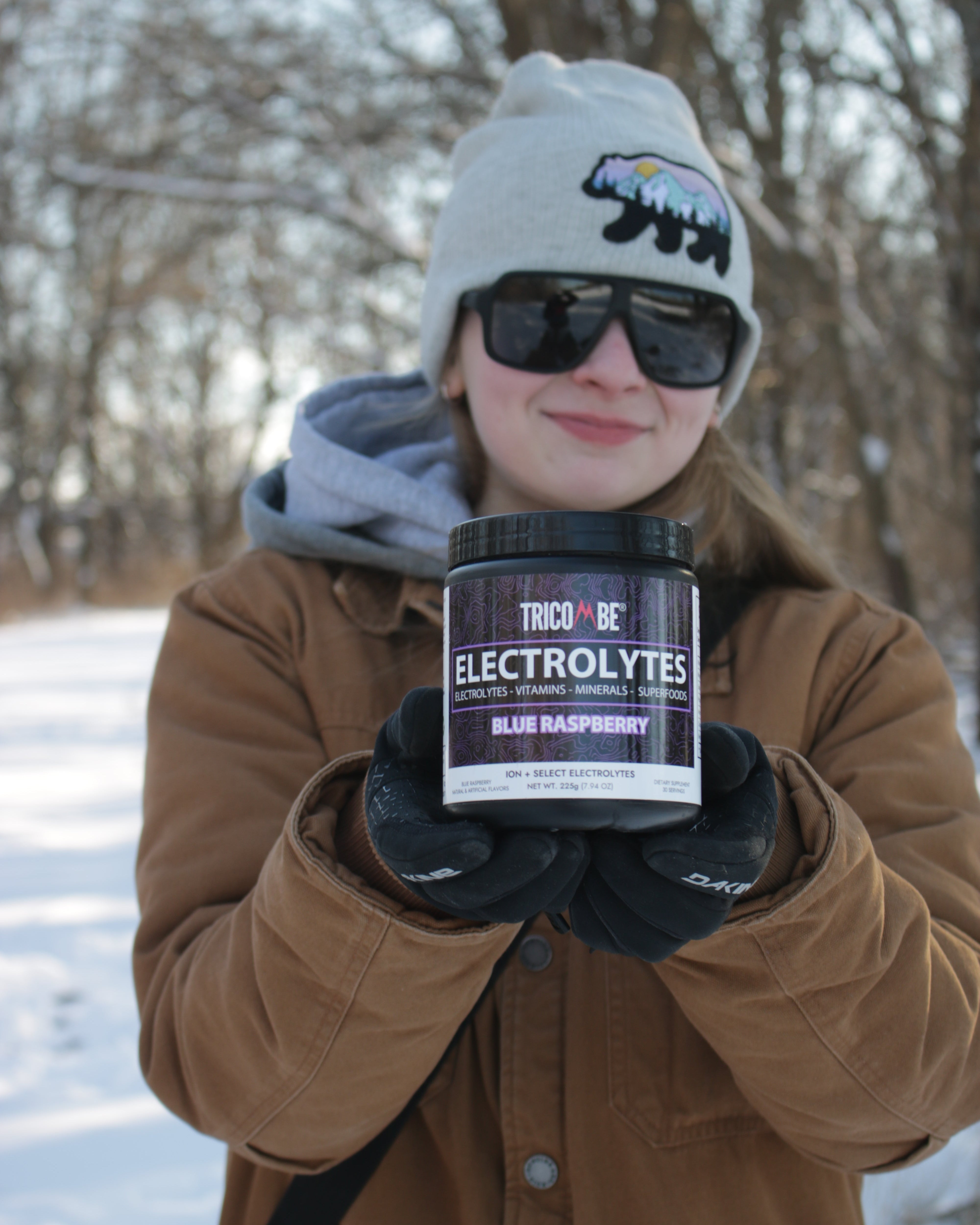 Person holding a supplement container outdoors in winter